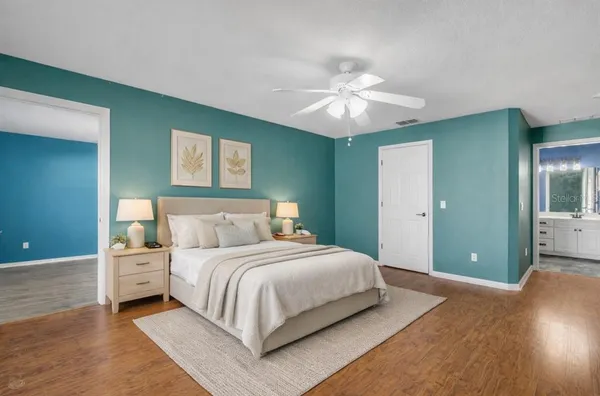 a bedroom with a large bed and a chandelier