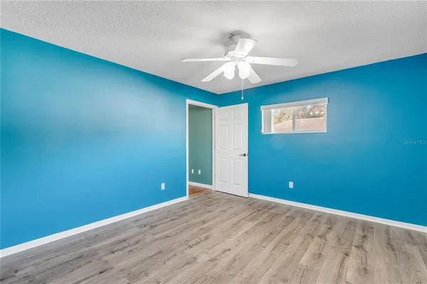 an empty room and chandelier fan
