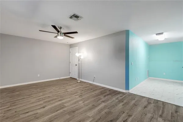 a view of a big room with wooden floor and a ceiling fan
