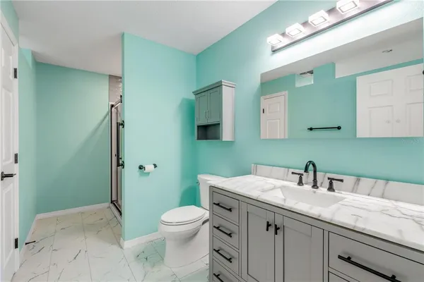 a bathroom with a granite countertop sink a toilet and a mirror