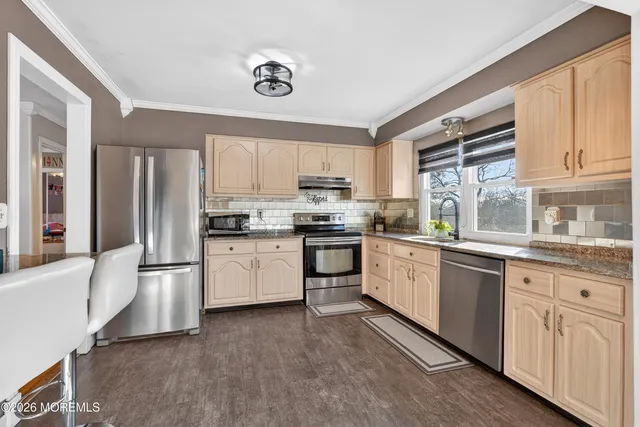 a kitchen with granite countertop white cabinets and stainless steel appliances