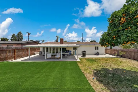a view of a house with patio and a yard