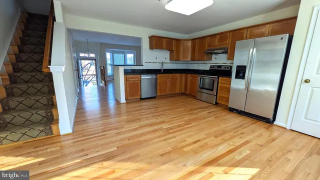 a kitchen with granite countertop a refrigerator and a sink