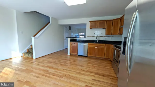 a kitchen with stainless steel appliances granite countertop a stove a sink and a refrigerator