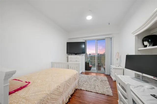 a room with lots of white furniture and wooden floor