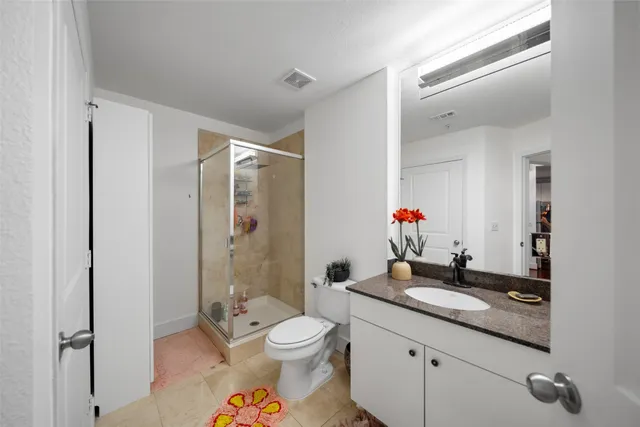 a bathroom with a granite countertop double vanity sink a mirror and a bathtub