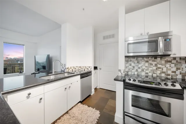a kitchen with granite countertop a sink and cabinets