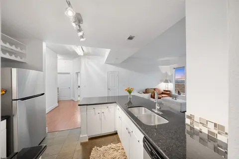 a kitchen with white cabinets and stainless steel appliances