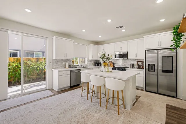 a kitchen with white cabinets and stainless steel appliances