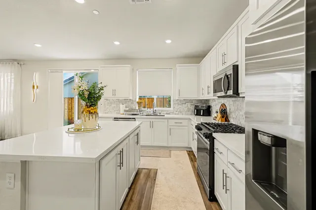 a kitchen with stainless steel appliances granite countertop a sink stove and refrigerator