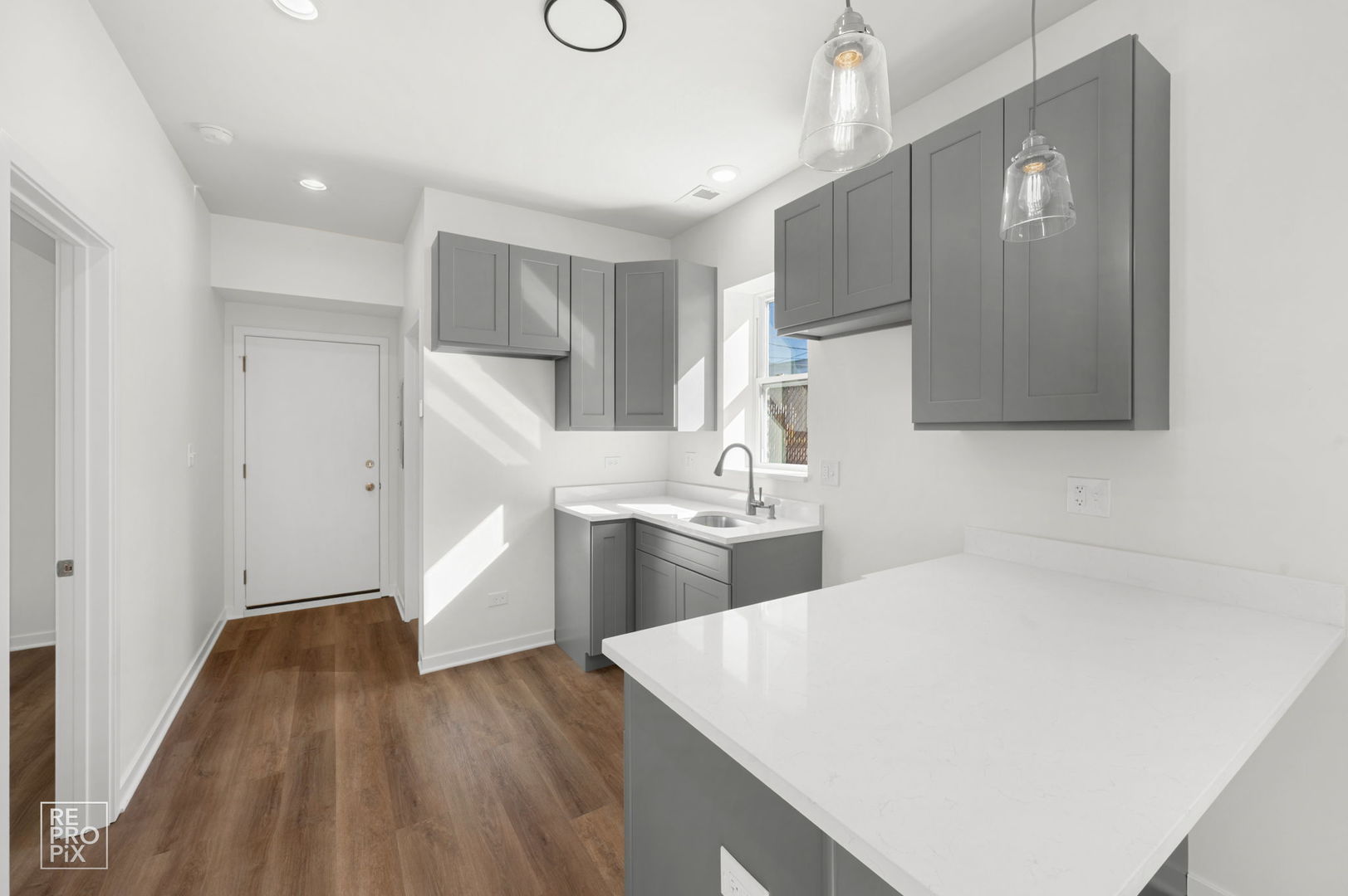 1624 West Pershing Road Chicago, IL 60609 - Photo 3 of 28 a kitchen with a sink a refrigerator and wooden floor