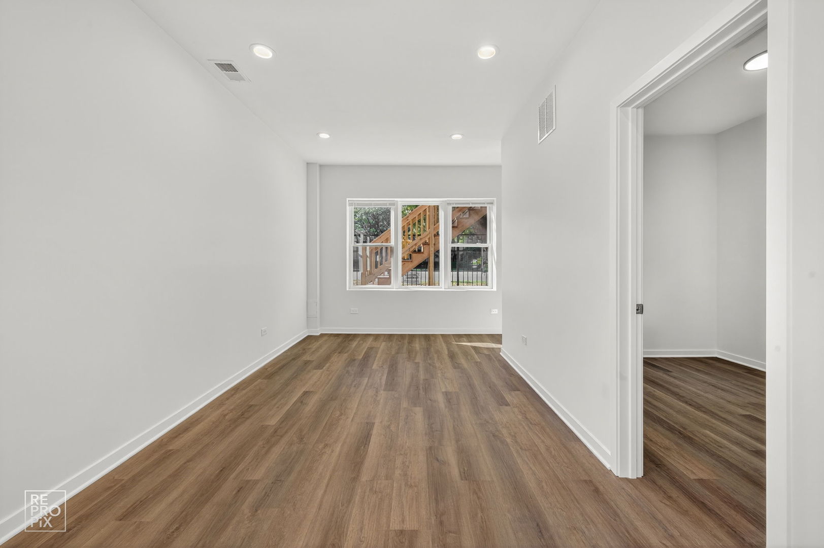 1624 West Pershing Road Chicago, IL 60609 - Photo 10 of 28 an empty room with wooden floor and windows