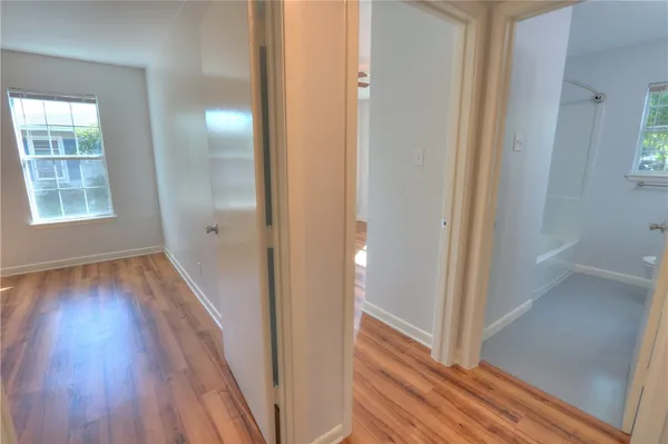 a view of a hallway with wooden floor and staircase