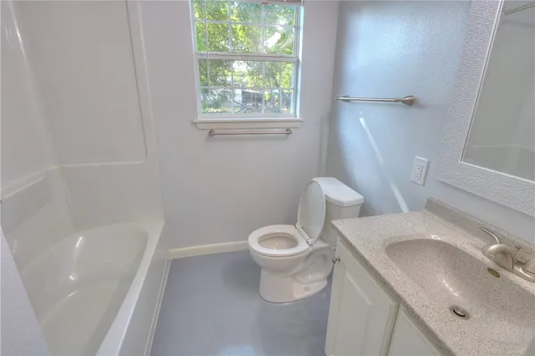 a white toilet sitting next to a bath tub