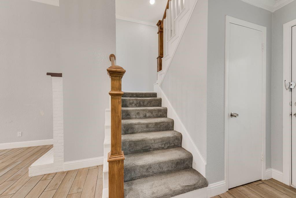 219 West Rochelle Road Irving, TX 75062 - Photo 19 of 29 Carpeted staircase with an ornate wood newel post and balusters