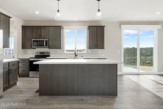 a kitchen with a sink a stove and a microwave