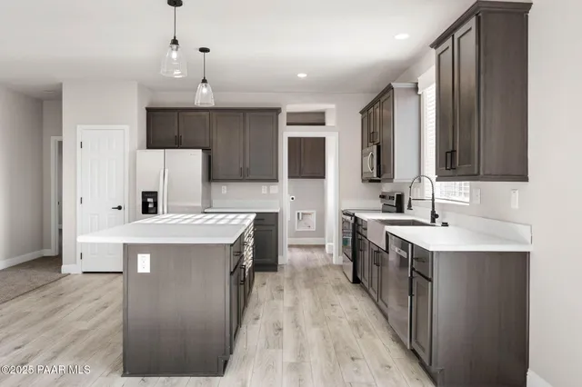 a kitchen with kitchen island a sink stove and refrigerator