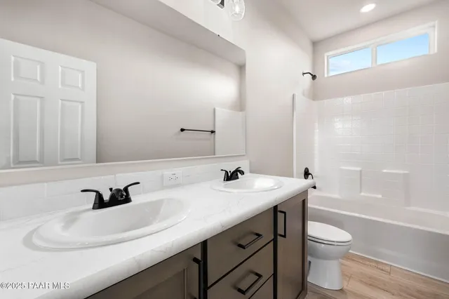 a bathroom with a sink a toilet and a large mirror