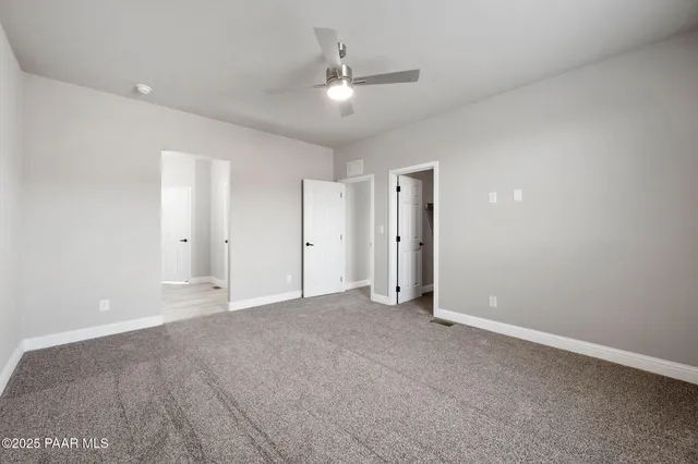 a view of an empty room with a ceiling fan