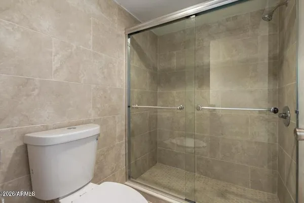 a white toilet sitting next to a bath tub and shower