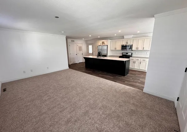 a living room with a couch and a view of kitchen