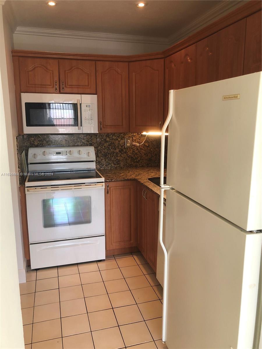 6901 Southwest 129th Avenue, Unit 5 Miami, FL 33183 - Photo 11 of 19 a kitchen with a stove top oven and cabinets