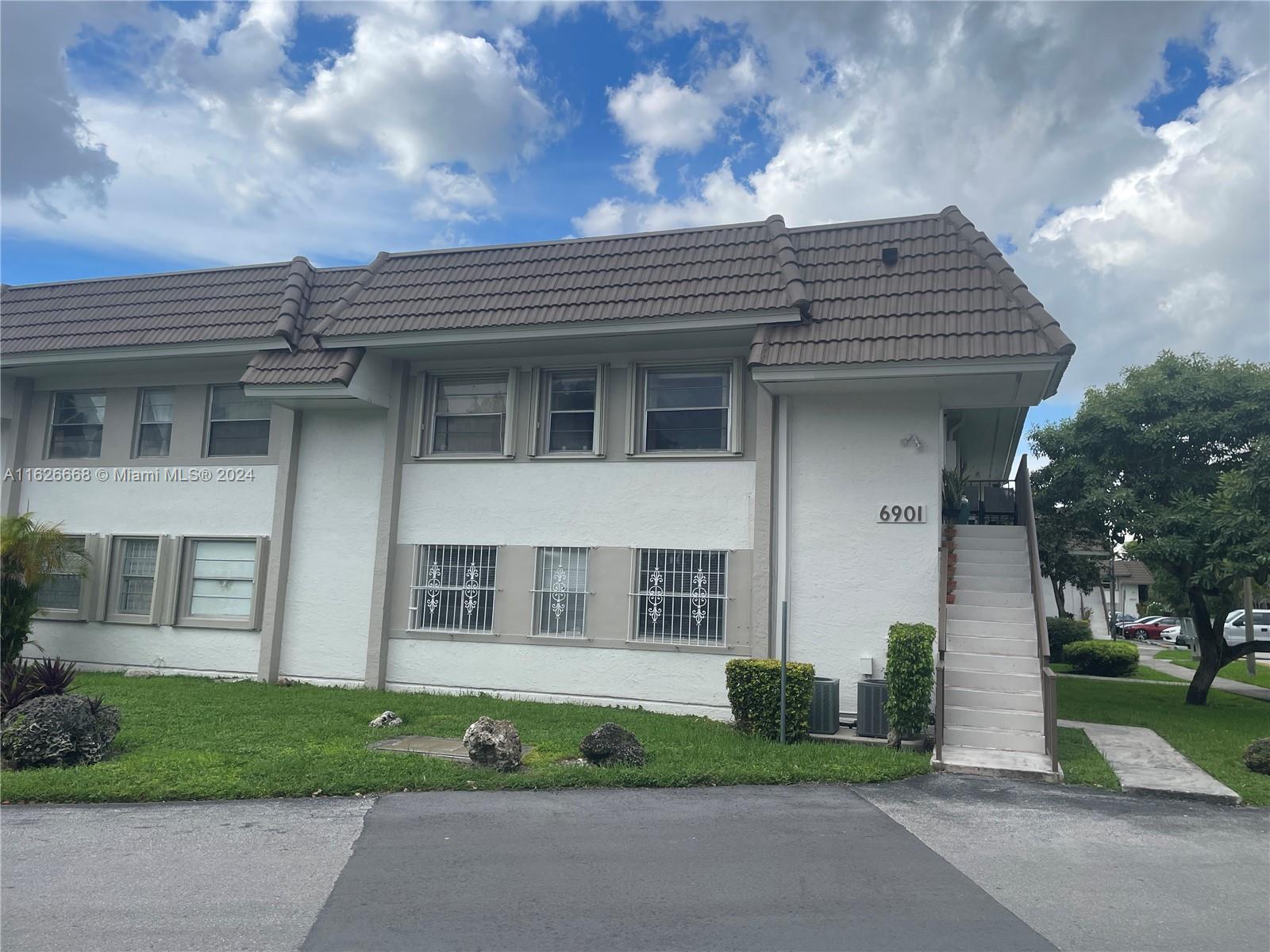 6901 Southwest 129th Avenue, Unit 5 Miami, FL 33183 - Photo 2 of 19 a front view of a house with a yard