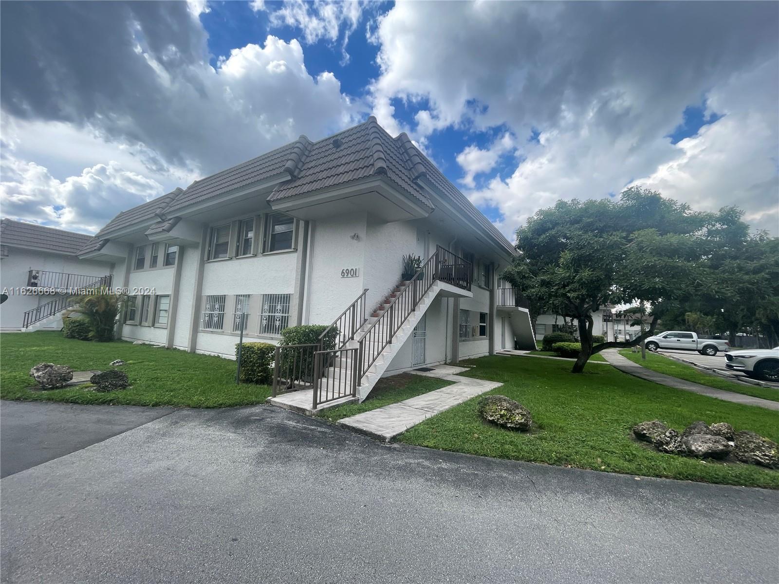 6901 Southwest 129th Avenue, Unit 5 Miami, FL 33183 - Photo 4 of 19 a view of a house with a big yard and a large tree