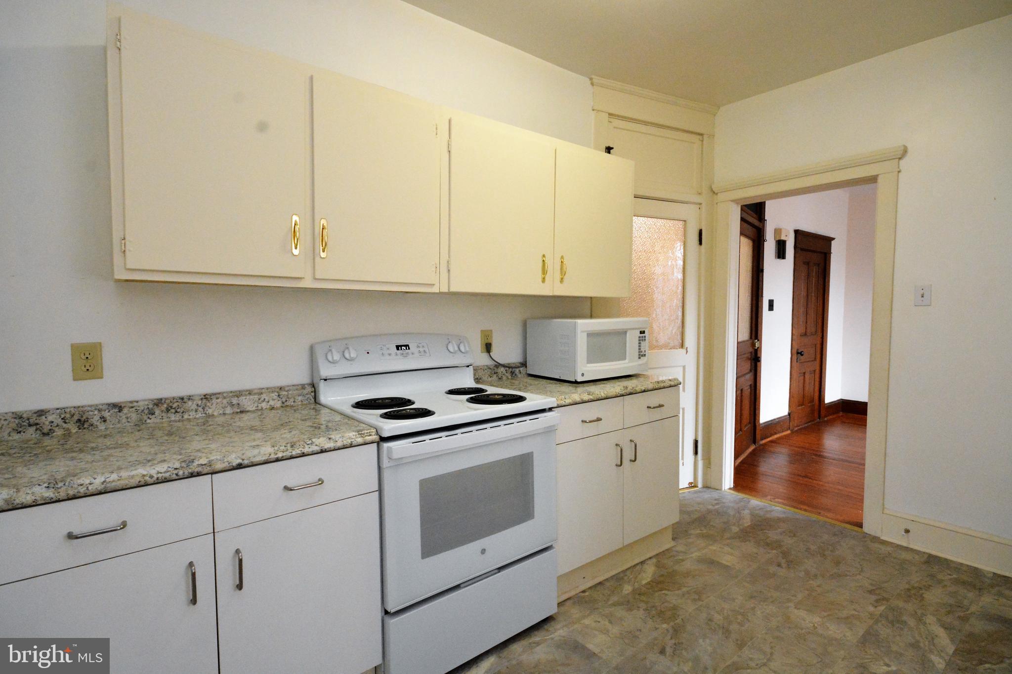 5 West Main Street, Unit 4 Middletown, MD 21769 - Photo 1 of 9 a kitchen with granite countertop white cabinets and white appliances