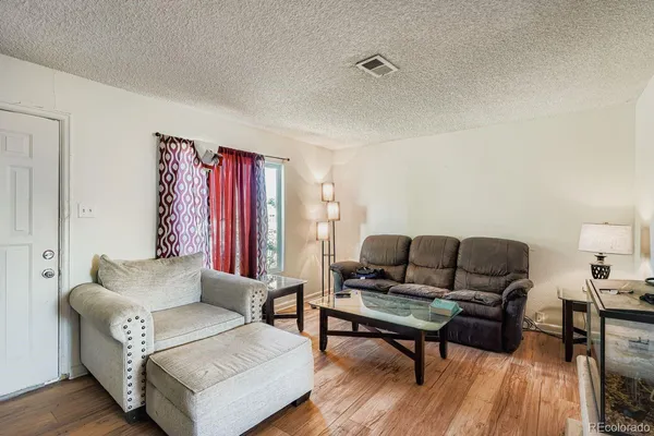 a living room with furniture and wooden floor