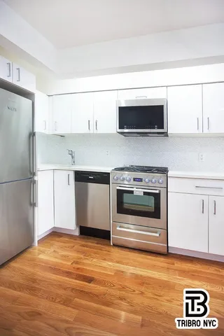 a kitchen with stainless steel appliances a stove a microwave and white cabinets