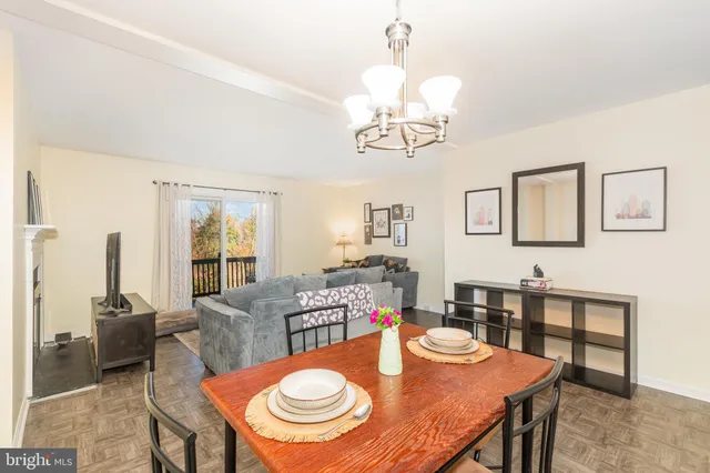 a view of a dining room with furniture a chandelier and wooden floor