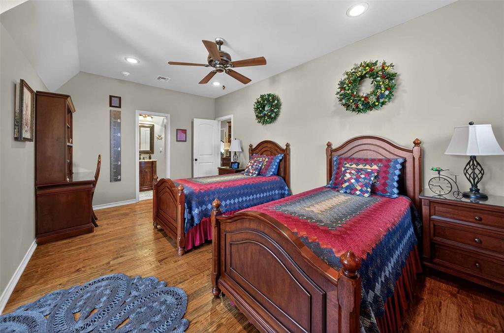 535 Riata Road Bullard, TX 75757 - Photo 20 of 40 a bedroom with a bed and a chandelier