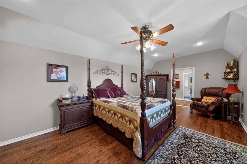 535 Riata Road Bullard, TX 75757 - Photo 21 of 40 a bedroom with bed and a chandelier
