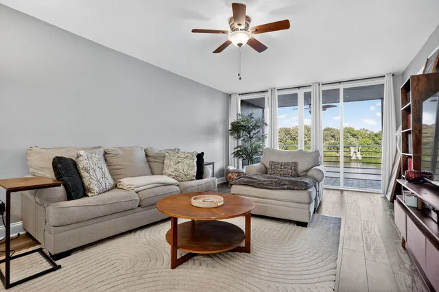 a living room with furniture a flat screen tv and a large window