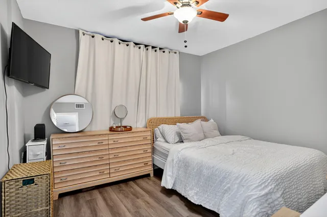 a bedroom with a bed a flat screen tv and chandelier