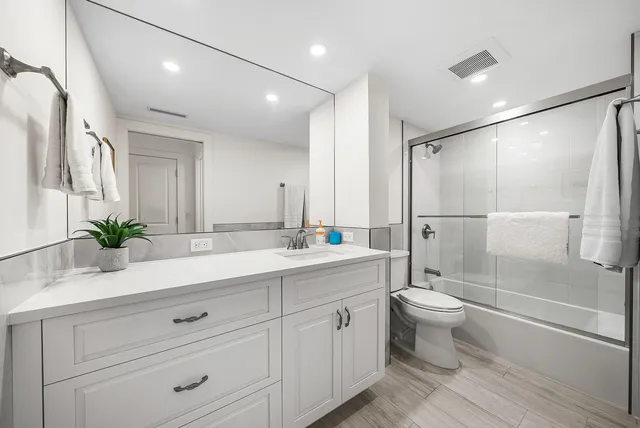 a bathroom with a double vanity sink toilet and shower