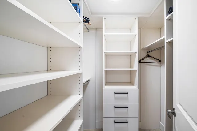 a view of walk in closet with empty racks