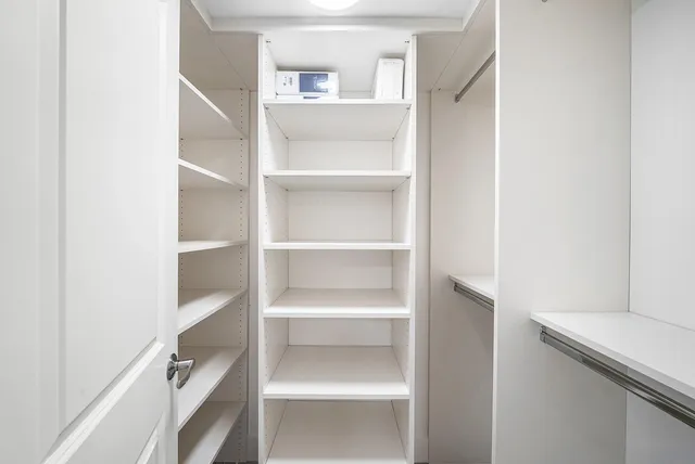 a view of walk in closet with empty racks