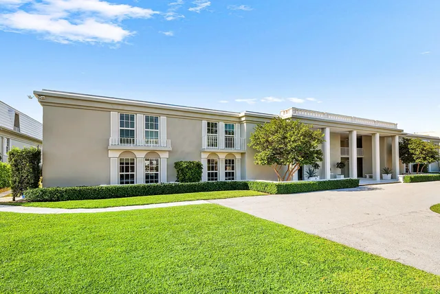 a view of a house with a big yard and large trees