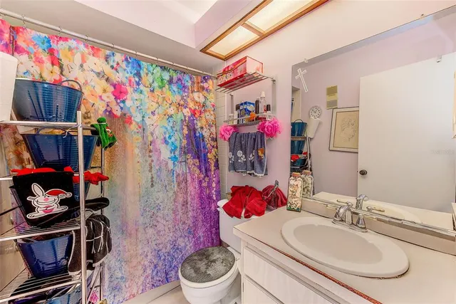 a bathroom with a sink vanity mirror and toilet