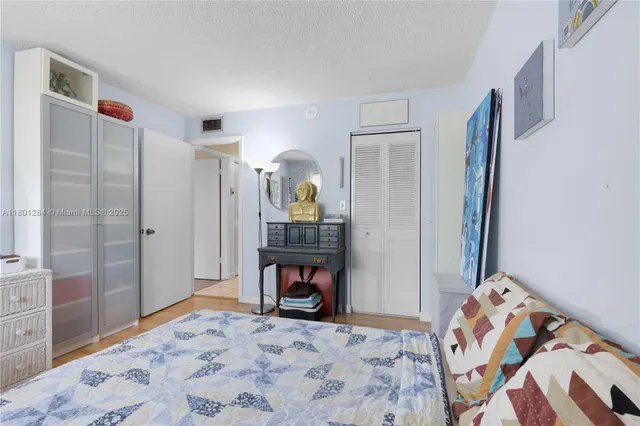 a bedroom with a bed and a dresser next to a window