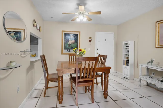 a view of a dining room with furniture and a chandelier fan