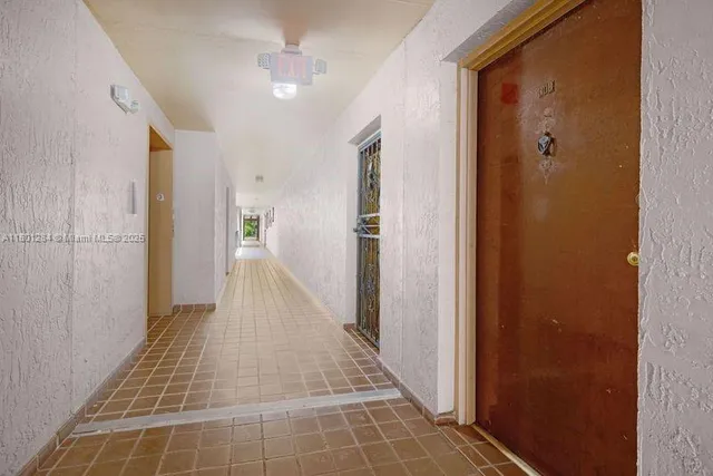 a view of a hallway with wooden floor and a bathroom