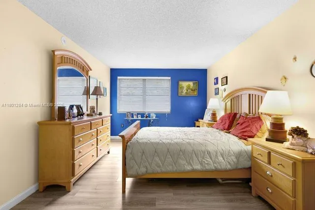 a bedroom with a bed and a dresser next to a window
