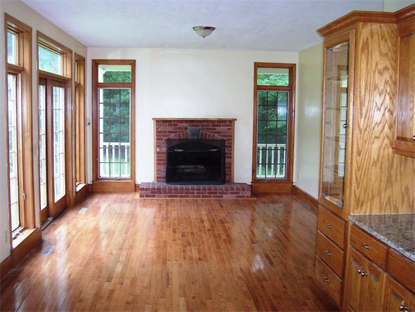 169 Scantic Road Hampden, MA 01036 - Photo 8 of 22 an empty room with wooden floor and a fireplace