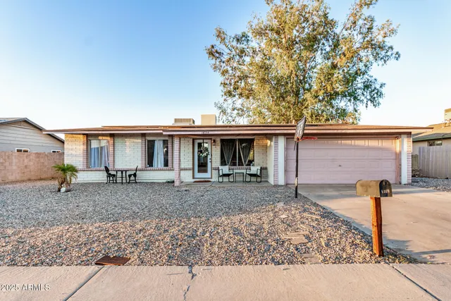 a view of a house with a backyard and chairs