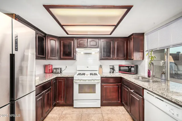 a kitchen with stainless steel appliances granite countertop a stove sink and cabinets