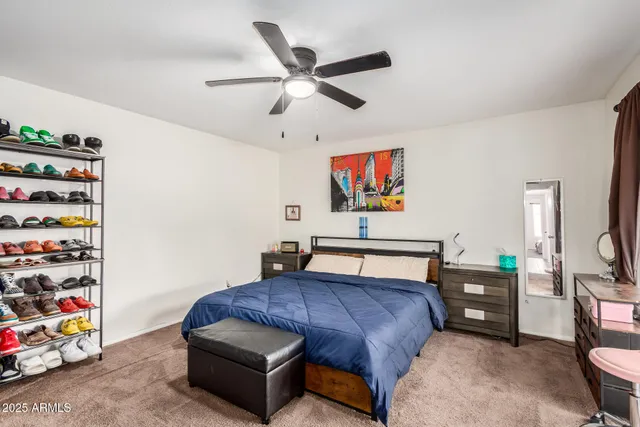 a spacious bedroom with a bed and a flat screen tv