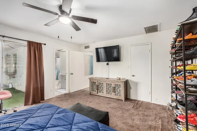 a bedroom with a bed and a tv on a dresser